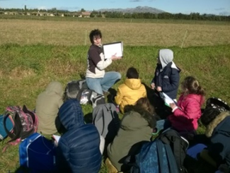 Emilie Vacher (CPIE) réalise une lecture de paysage en Crau avec les élèves.